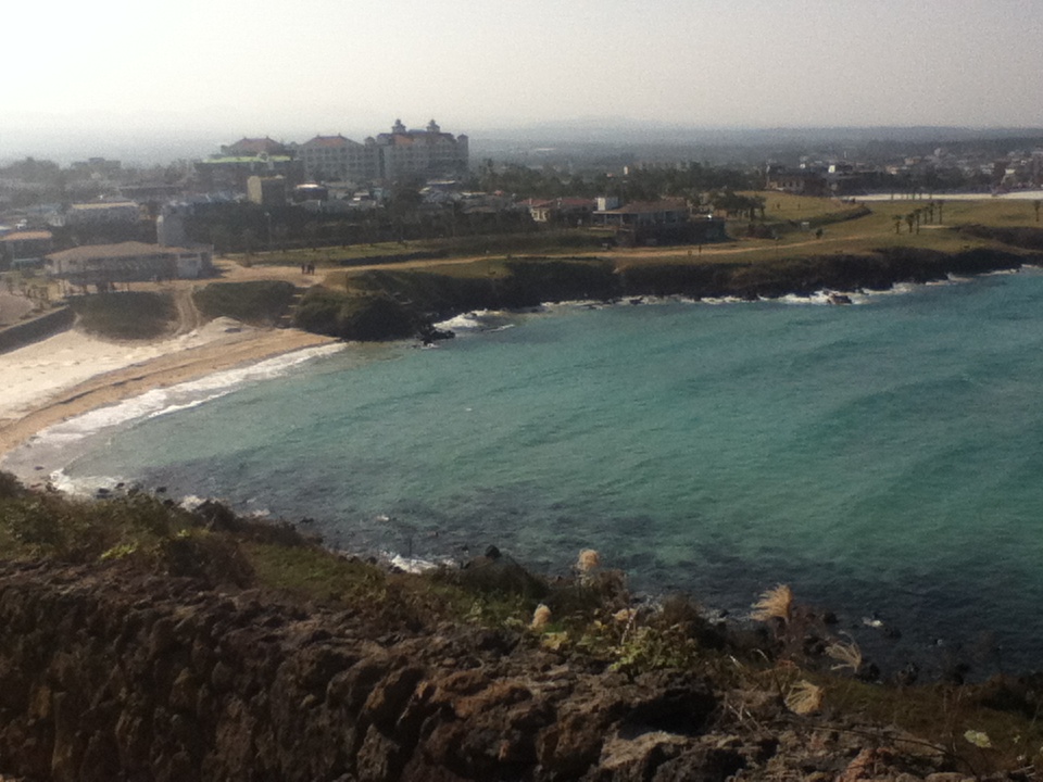 Sandy shoreline and turquoise water at Hamdeok Beach, Jeju