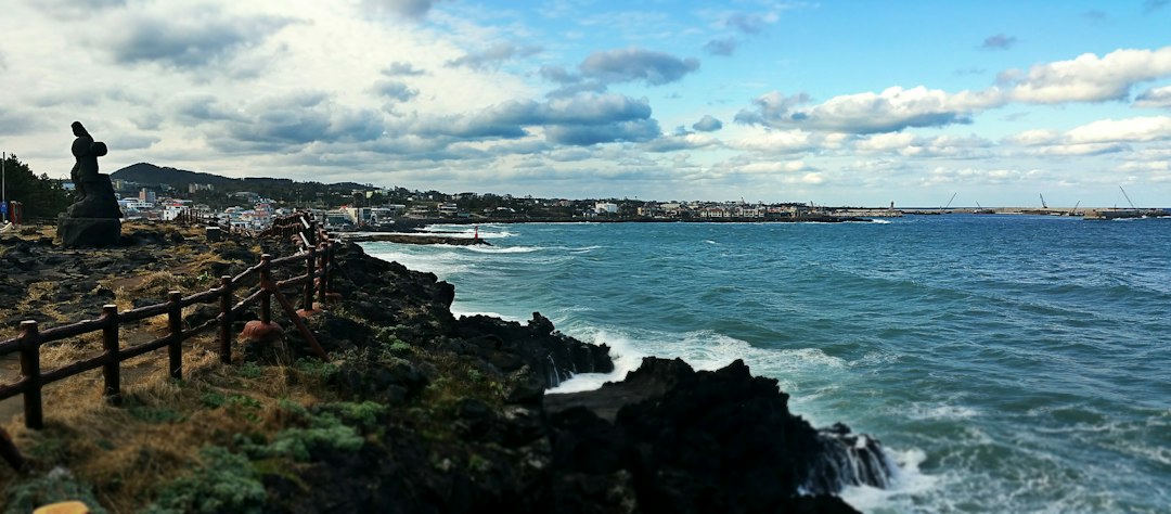 Rocky Jeju coastline with a walking path and sea view