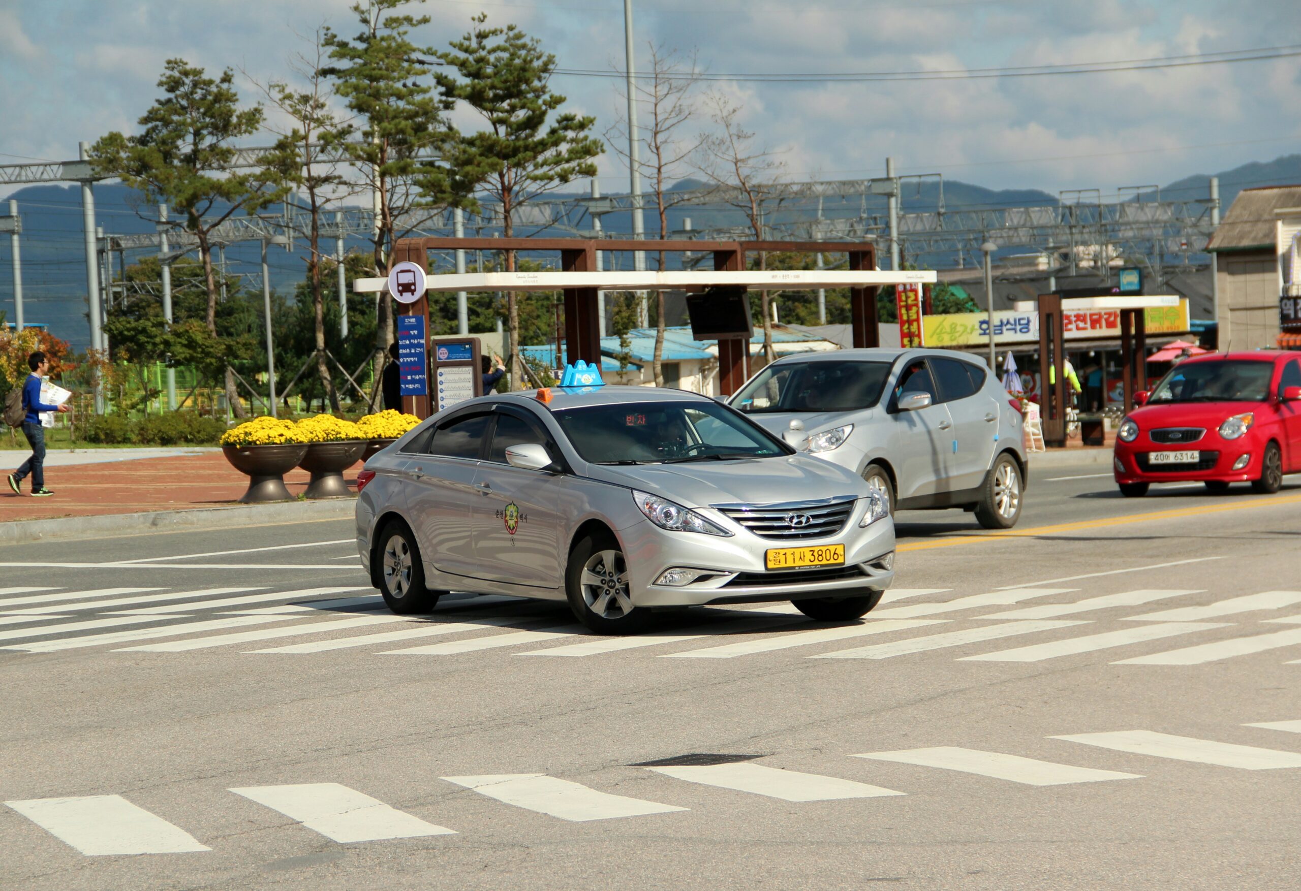 Silver taxi driving on a road in Seoul
