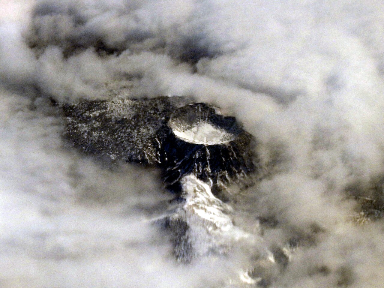 Snow-covered Hallasan crater seen through clouds from an airplane in February