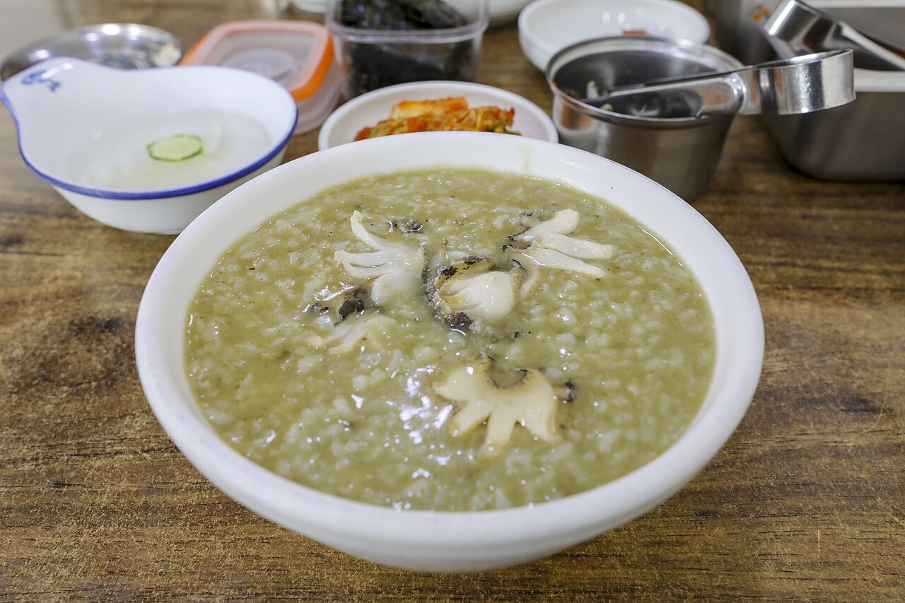 Abalone porridge topped with sliced abalone, photographed in Busan